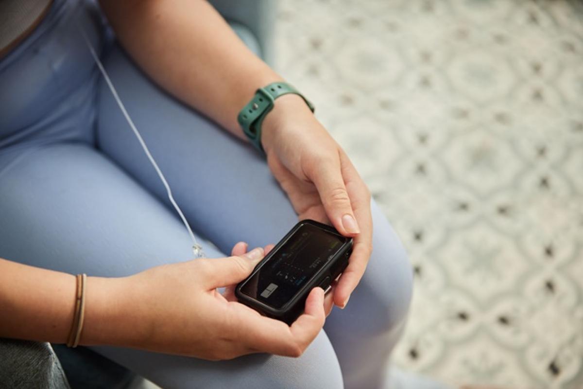Person looking at a tethered insulin pump